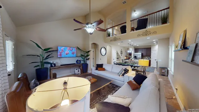a living room with furniture a dining table and a chandelier