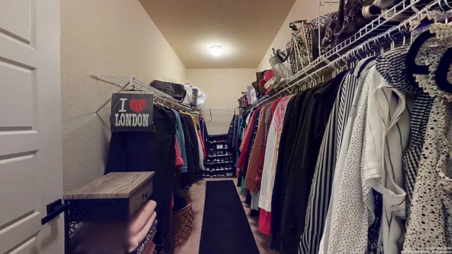 a view of walk in closet with clothes