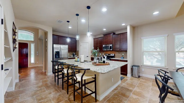 a kitchen with a dining table chairs and refrigerator