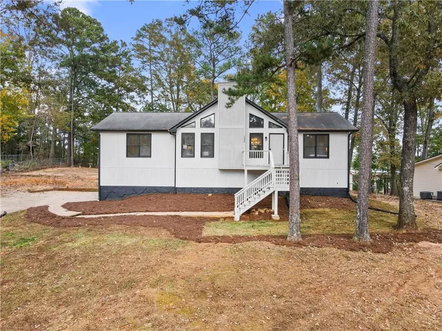 a view of a house with a yard and large tree