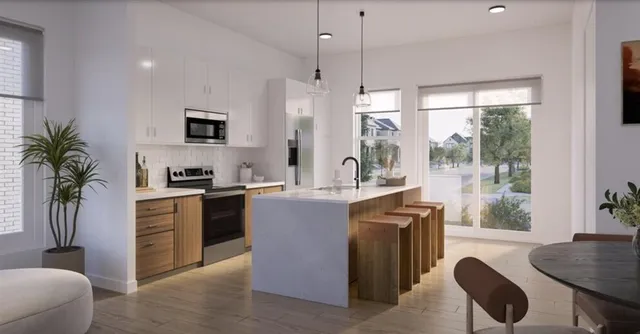 a kitchen with stainless steel appliances a refrigerator a stove a sink a dining table and chairs with wooden floor