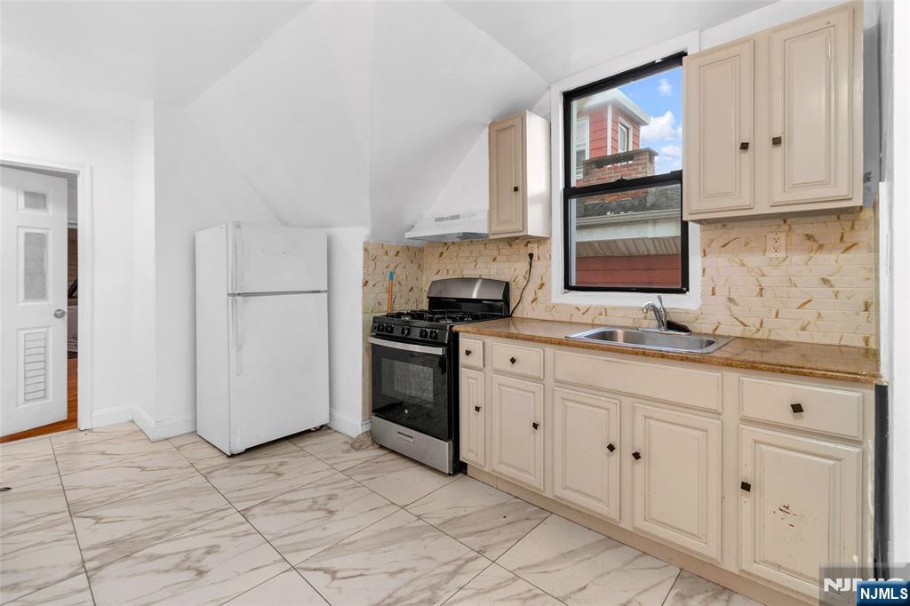 25 Oak Street Paterson, NJ 07501 - Photo 16 of 25 a kitchen with granite countertop white cabinets stainless steel appliances and sink