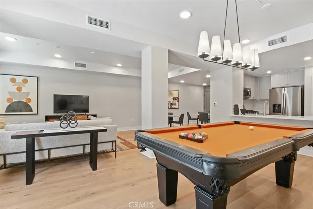 a room with furniture pool table and a flat screen tv