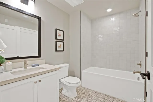 a bathroom with a bathtub shower sink vanity and toilet