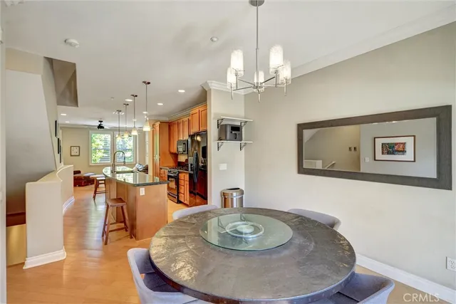 a dining room with wooden floor a chandelier a wooden table and chairs