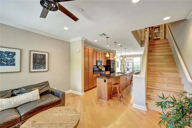 a living room with furniture and a dining table with kitchen appliances