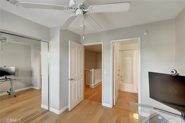 a view of a hallway with a chandelier fan and wooden floor
