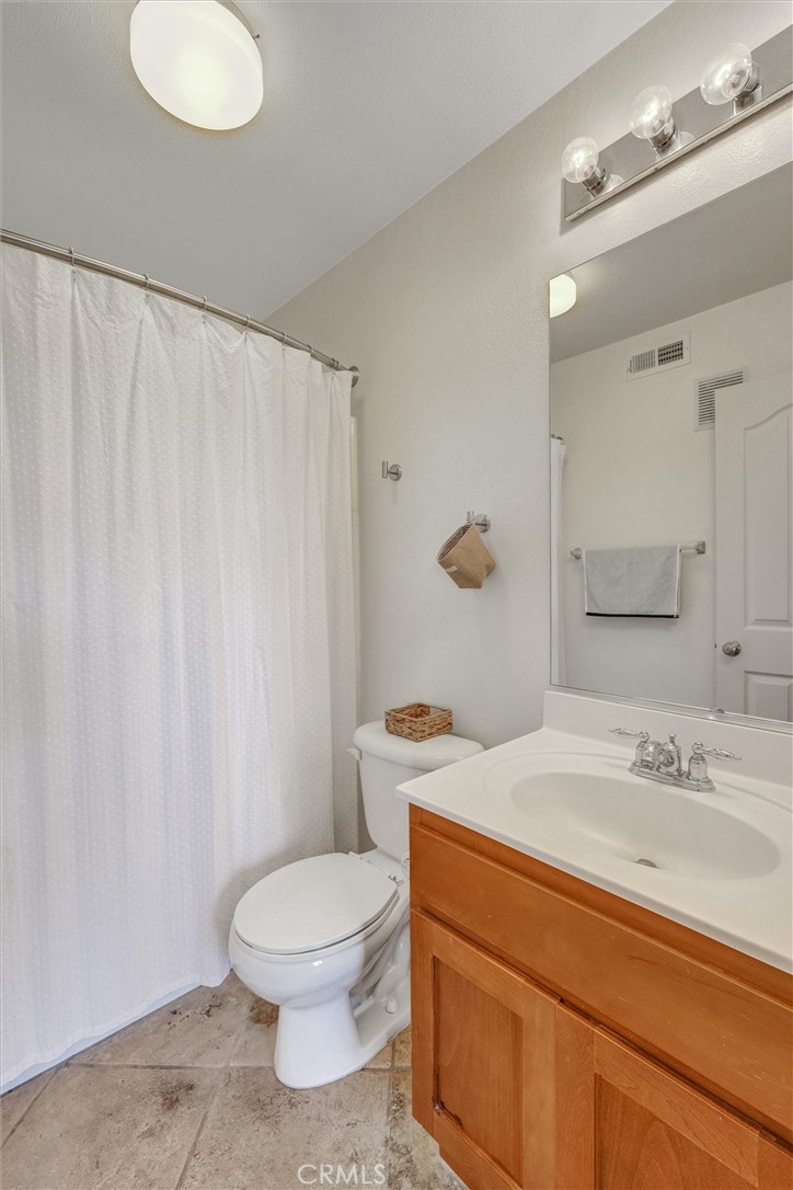 1159 Elfin Forest Road San Marcos, CA 92078 - Photo 23 of 40 a bathroom with a sink a toilet and shower curtain