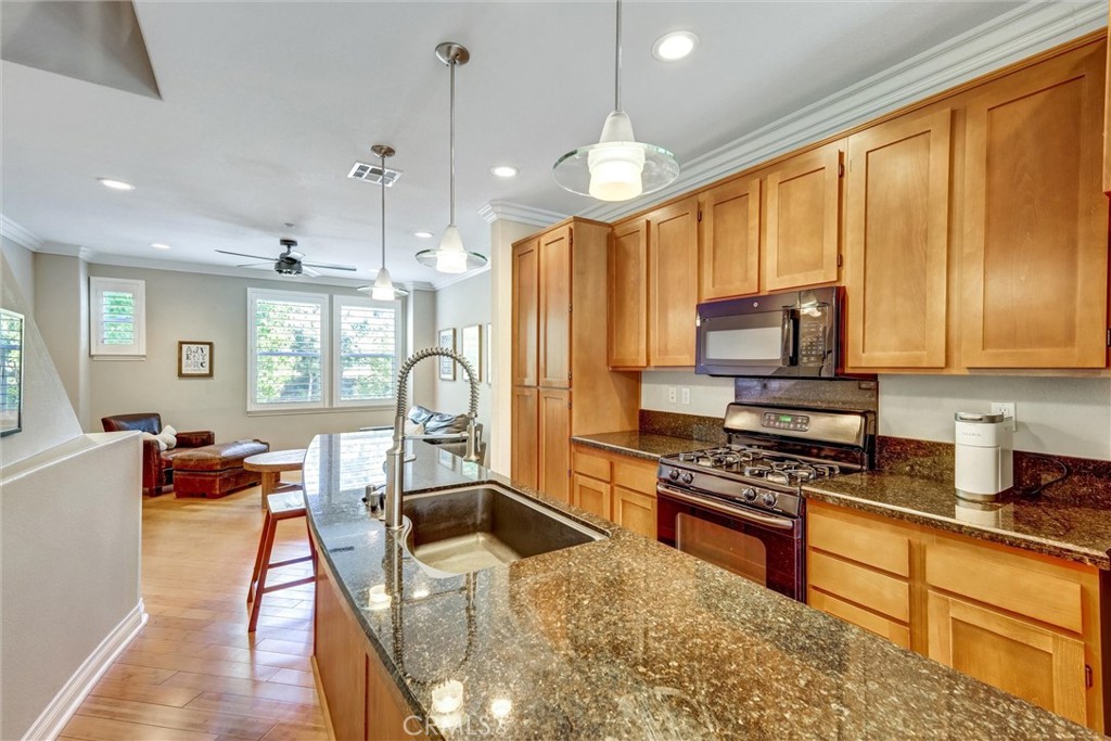 1159 Elfin Forest Road San Marcos, CA 92078 - Photo 3 of 40 a large kitchen with stainless steel appliances granite countertop a stove a sink dishwasher a dining table and chairs with wooden floor