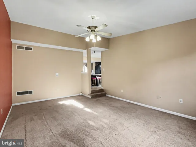 a view of an empty room with a ceiling fan