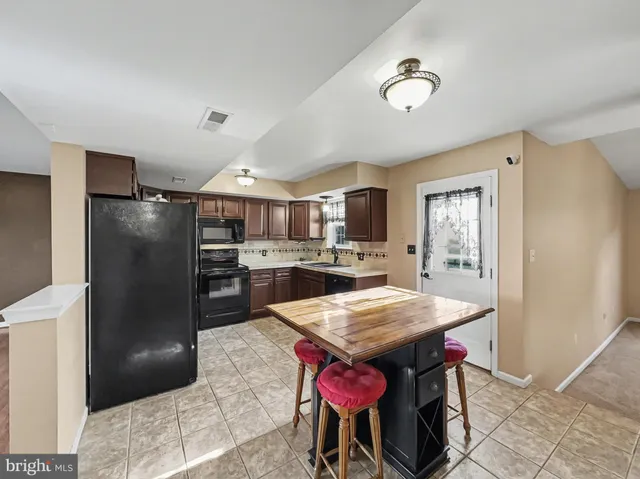 a kitchen with granite countertop a refrigerator and wooden cabinets