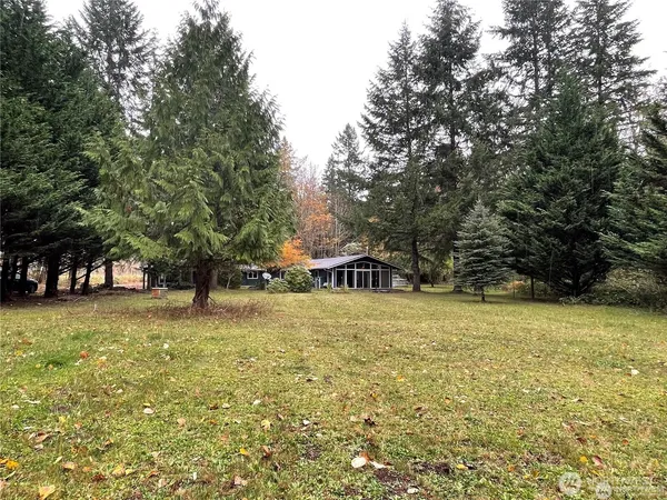 a tall yellow house with lots of trees in front of it