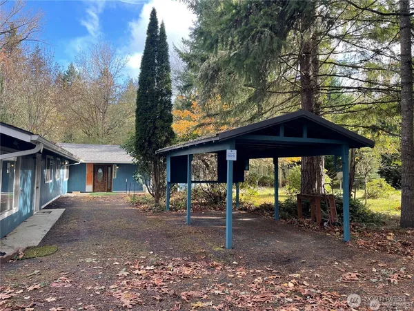 a view of a house with backyard and trees