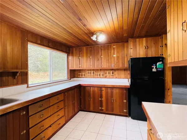 a kitchen with stainless steel appliances granite countertop a refrigerator a sink dishwasher and wooden cabinets