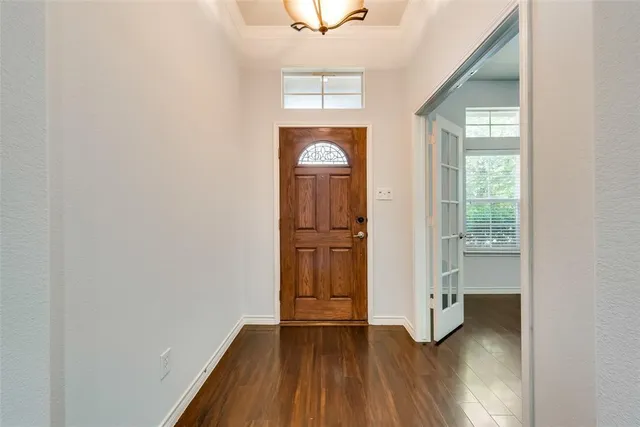 a view of an empty room with window and wooden floor