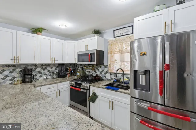 a kitchen with stainless steel appliances a refrigerator sink and cabinets