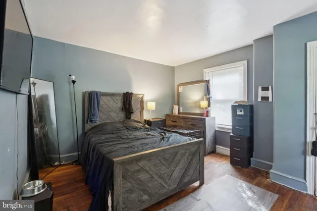 a bedroom with a bed and a refrigerator