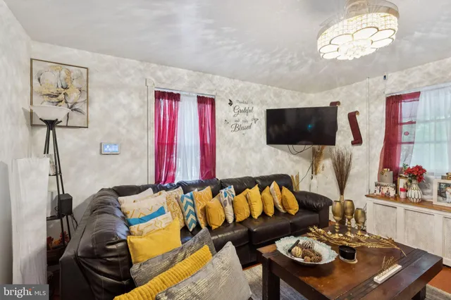 a living room with furniture a flat screen tv and kitchen view