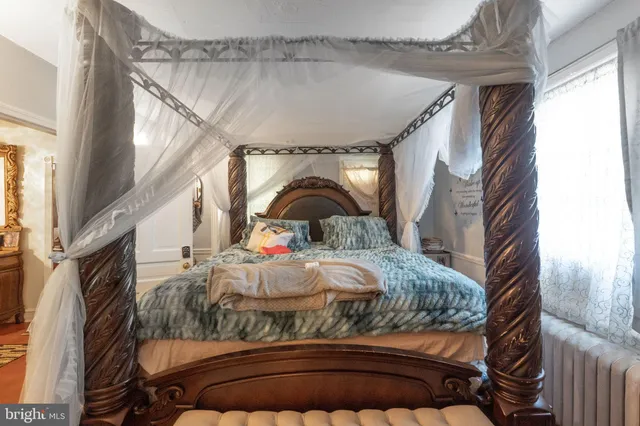 a bed sitting in a bedroom next to a window