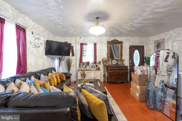 a living room with furniture a flat screen tv and wooden floor