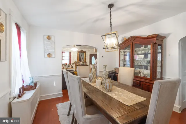 a dining room with furniture a chandelier and wooden floor
