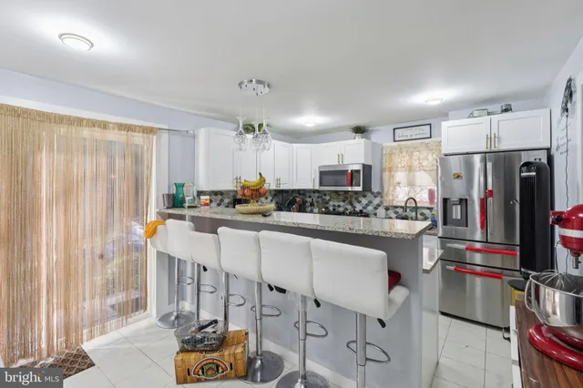 a kitchen with stainless steel appliances granite countertop a refrigerator and a stove top oven