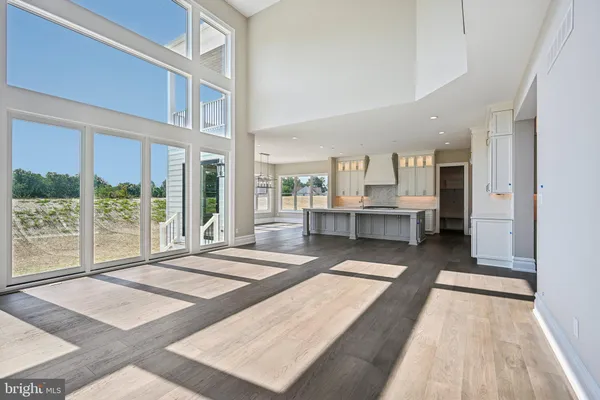 a view of a kitchen with white cabinets and wooden floor
