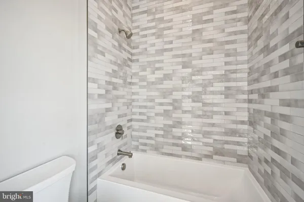 a spacious bathroom with a double vanity sink a mirror and a bathtub