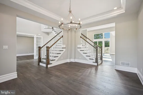 a view of an entryway with wooden floor front door and windows