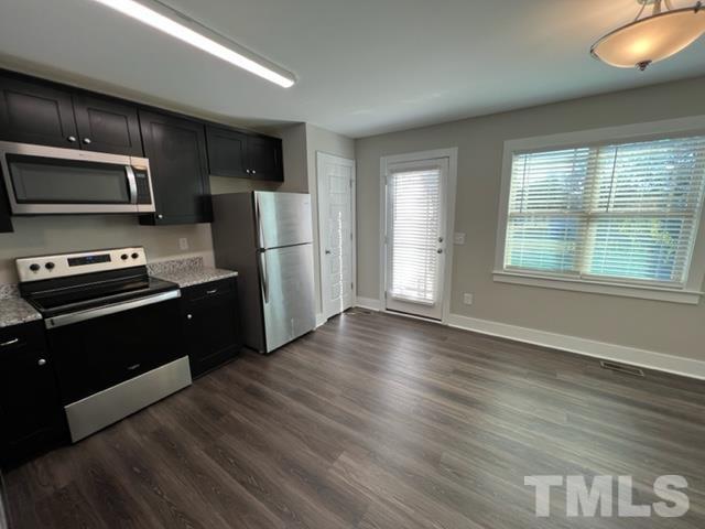 355 South Church Street Coats, NC 27521 - Photo 6 of 17 a kitchen with stainless steel appliances wooden floors and wooden cabinets