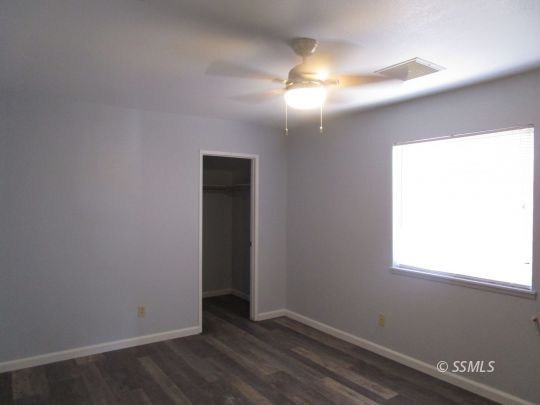 910 East Church Avenue Ridgecrest, CA 93555 - Photo 16 of 20 an empty room with wooden floor and windows