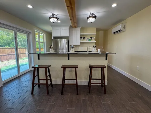 a kitchen with stainless steel appliances granite countertop a kitchen island hardwood floor sink stove dining table and chairs