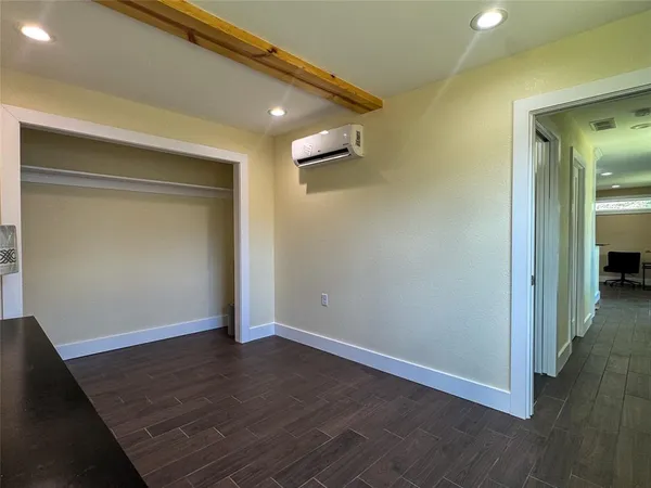 an empty room with wooden floor and closet