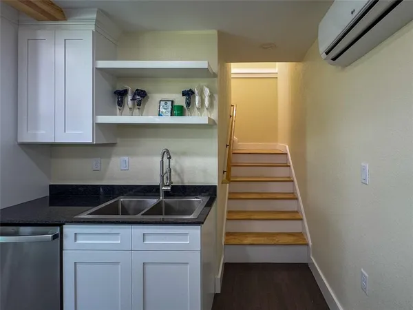 a kitchen with granite countertop a sink and cabinets