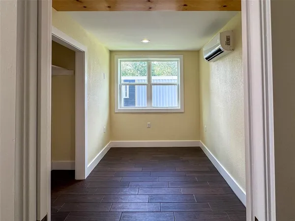 an empty room with wooden floor and a window
