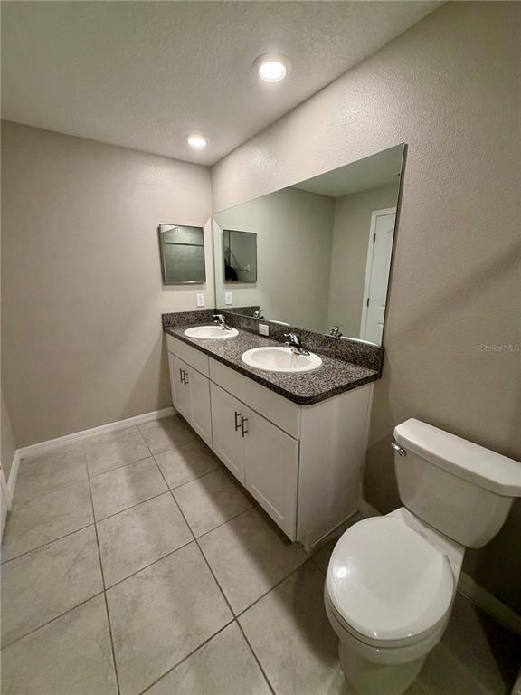11826 Dumaine Valley Road Riverview, FL 33579 - Photo 27 of 54 a bathroom with a granite countertop toilet sink and mirror