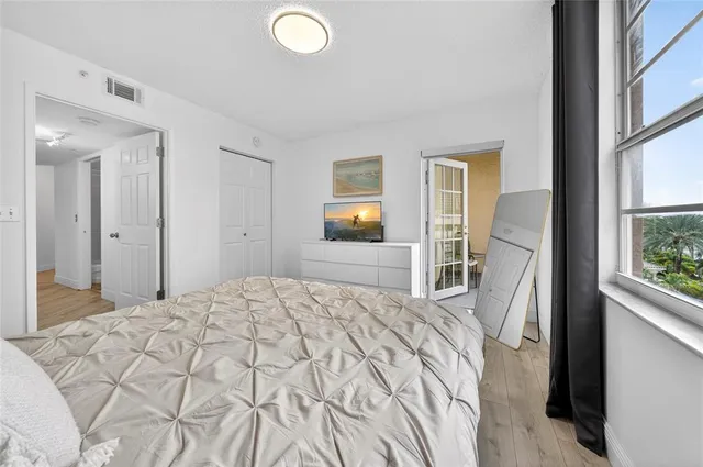 a bedroom with a bed and a large window