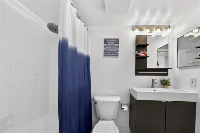 a bathroom with a sink mirror toilet and shower