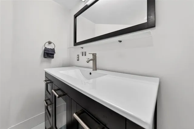 a bathroom with a sink vanity and a mirror