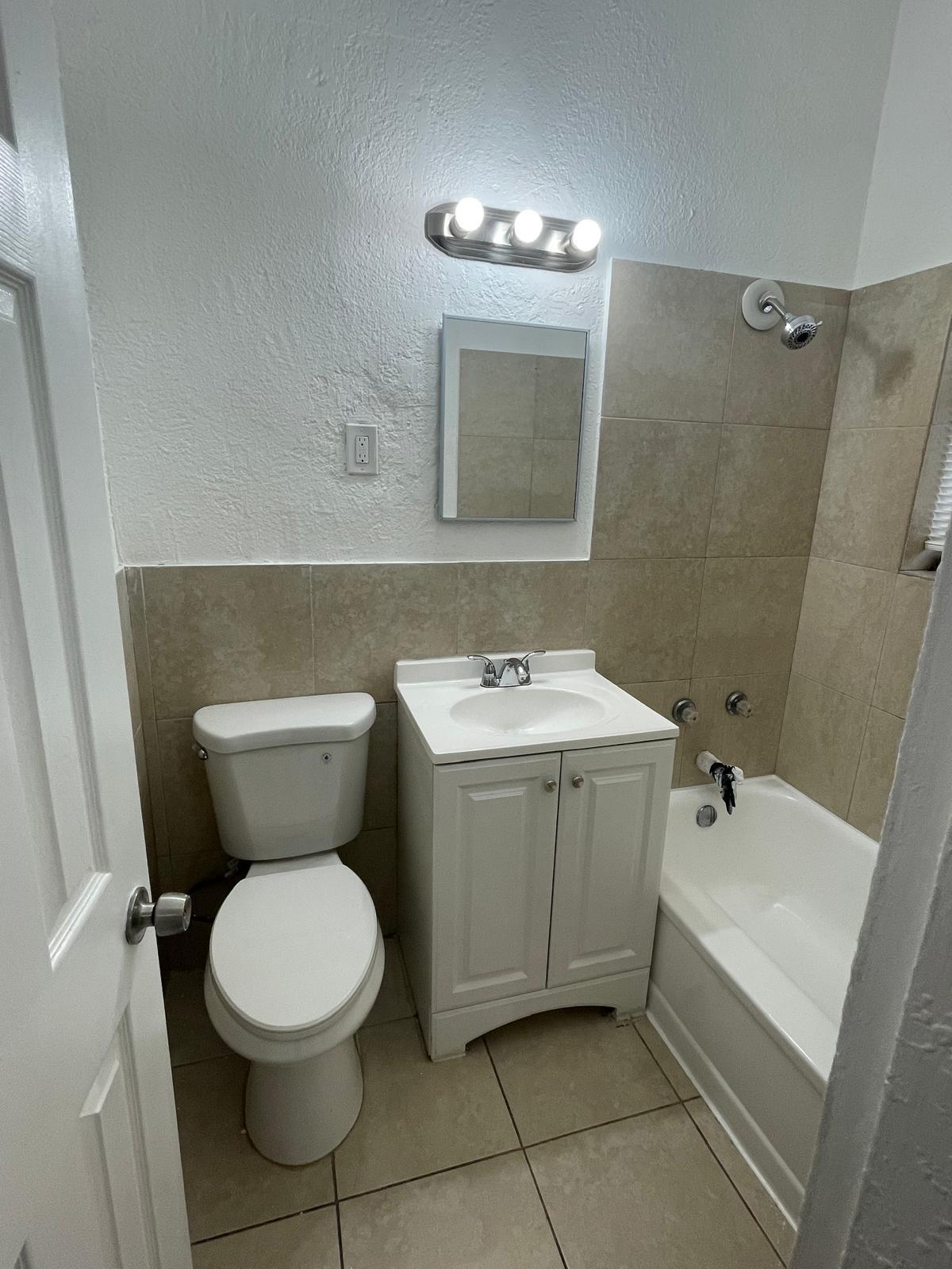 6910 Byron Avenue, Unit 3 Miami Beach, FL 33141 - Photo 11 of 12 a bathroom with a toilet sink and mirror