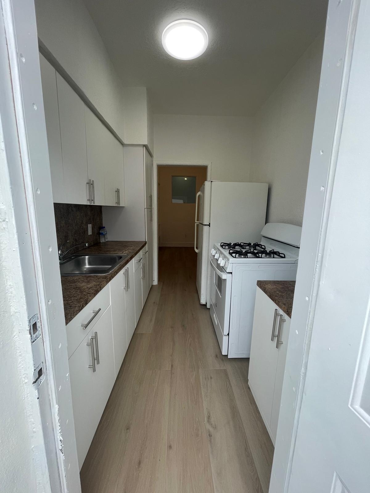 6910 Byron Avenue, Unit 3 Miami Beach, FL 33141 - Photo 4 of 12 a kitchen with a sink and a stove top oven