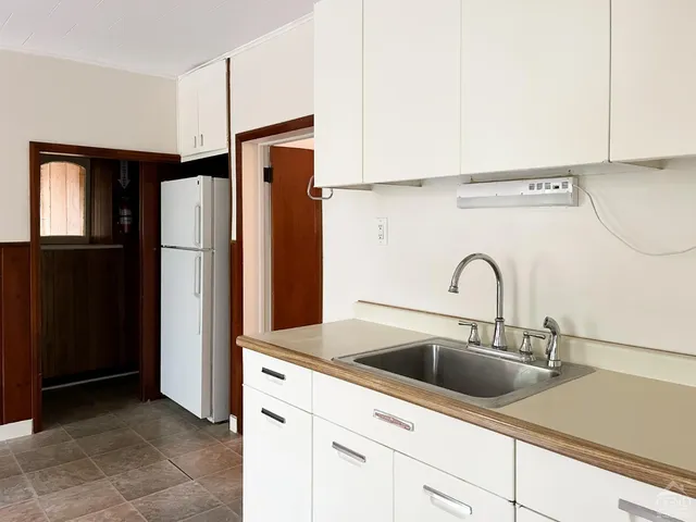 a kitchen with cabinets stainless steel appliances and sink