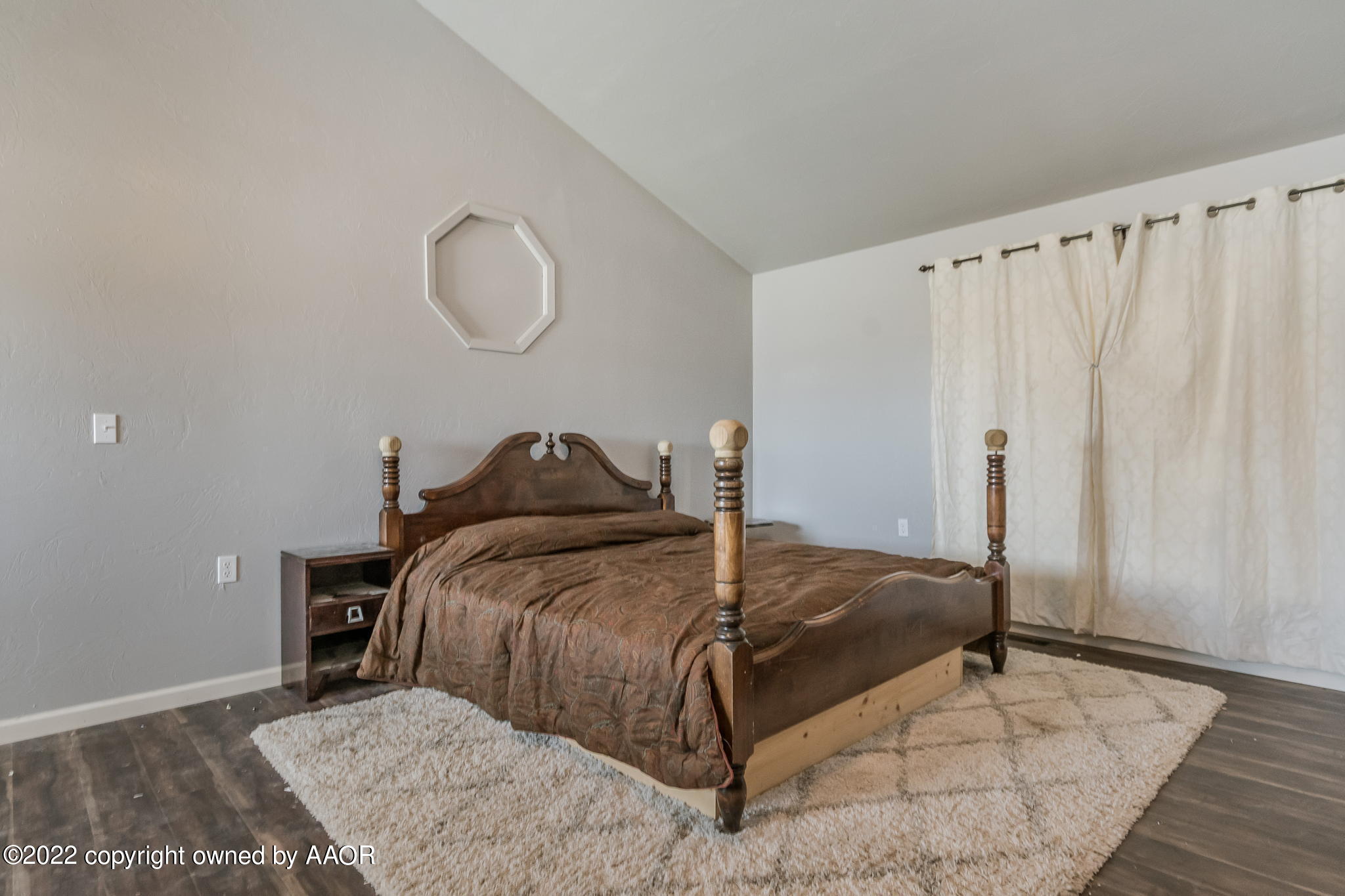 100 Alamo Street Claude, TX 79019 - Photo 20 of 39 a bed sitting in a bedroom next to a window and a wooden floor