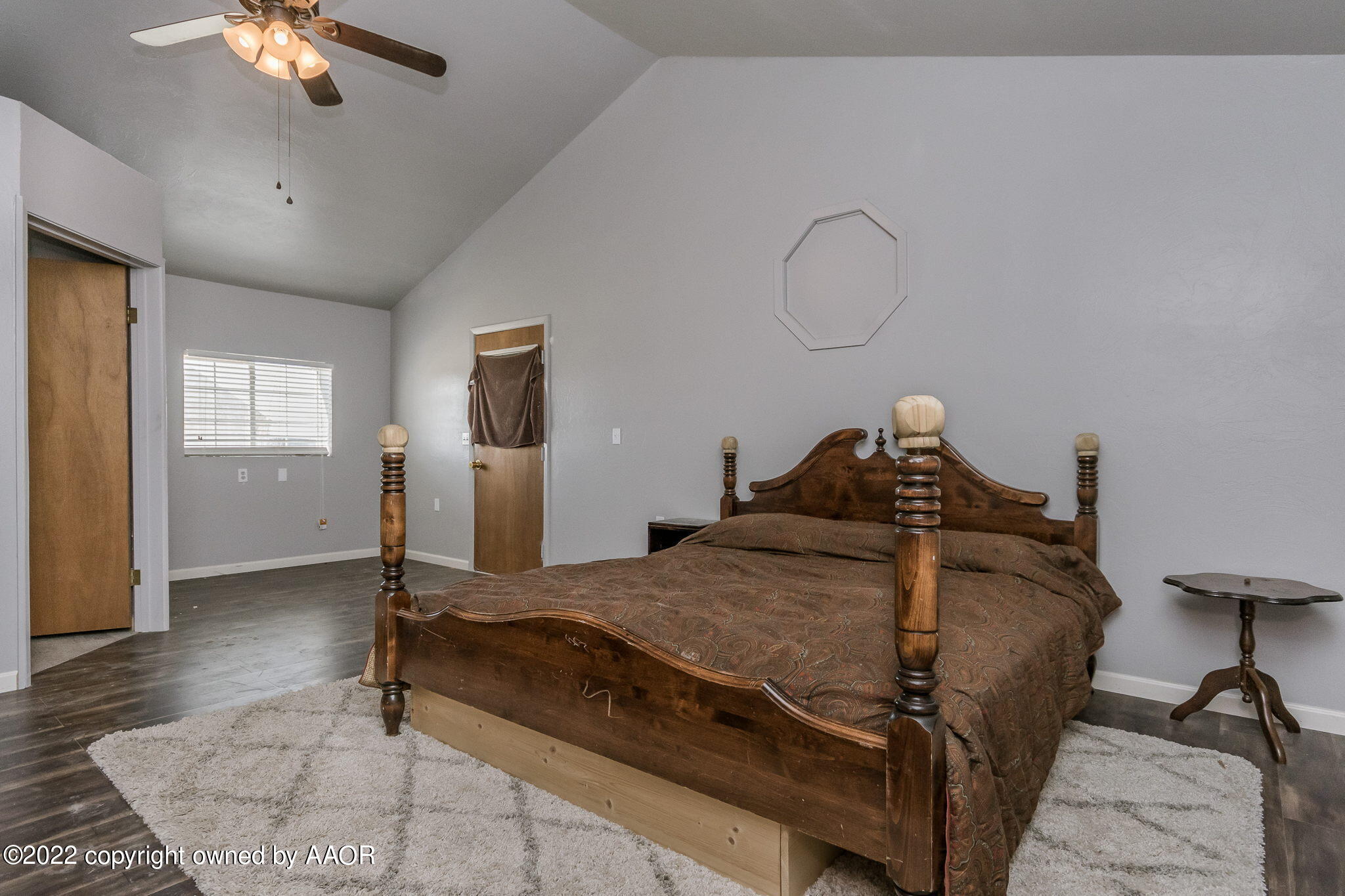100 Alamo Street Claude, TX 79019 - Photo 21 of 39 a bed sitting in a spacious bedroom next to a window and a chandelier