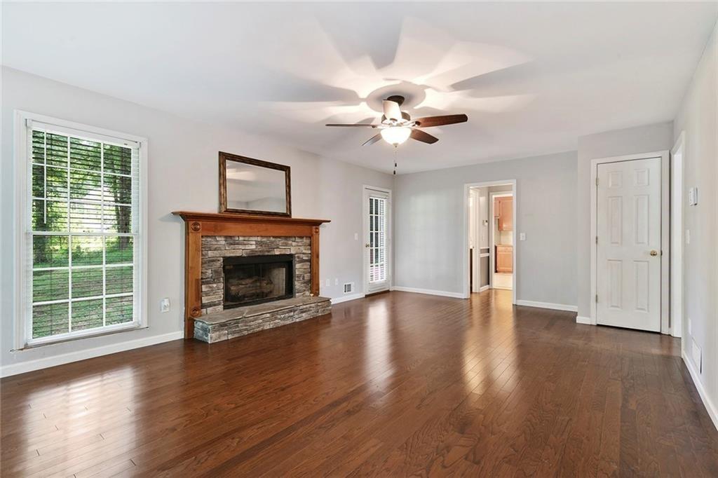 4235 Doubletree Court Cumming, GA 30040 - Photo 4 of 24 a view of an empty room with wooden floor fireplace and a window