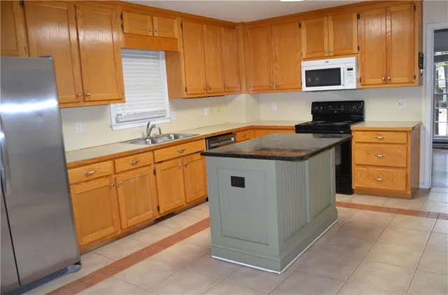 a kitchen with stainless steel appliances granite countertop a stove a sink and a microwave