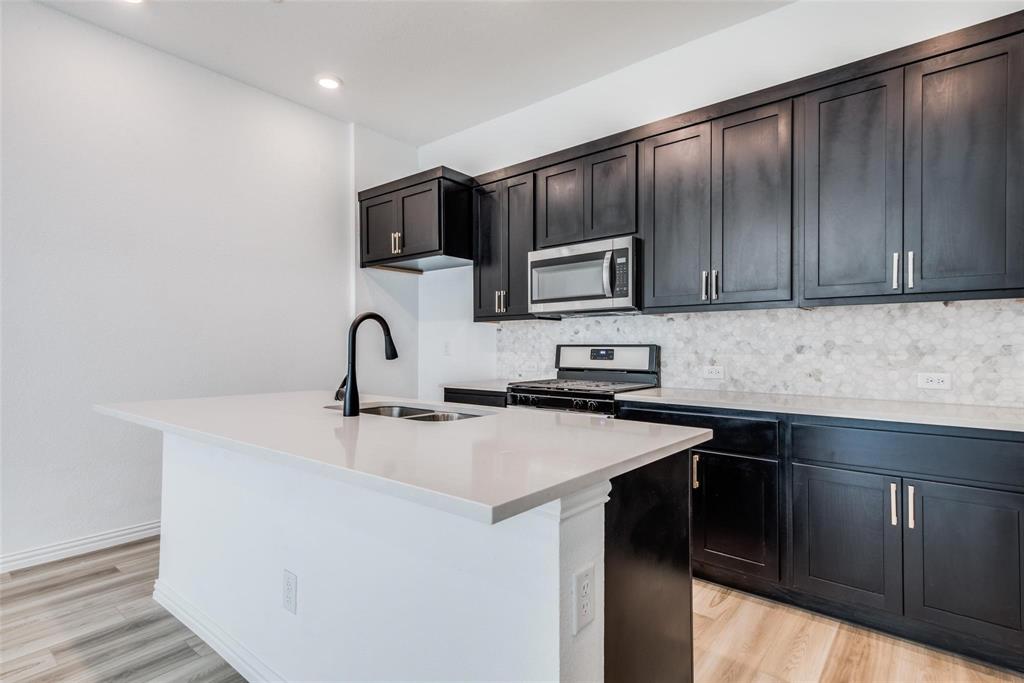 9915 Schramm Street Irving, TX 75063 - Photo 4 of 12 a kitchen with stainless steel appliances granite countertop a sink stove and microwave