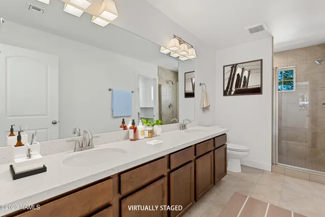 a bathroom with a double vanity sink mirror and toilet