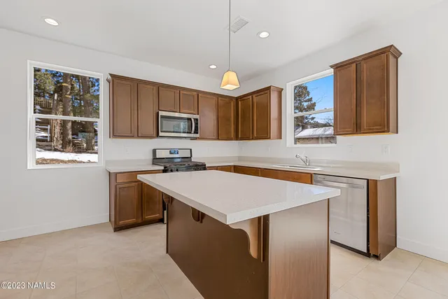 a kitchen with kitchen island a stove sink and microwave