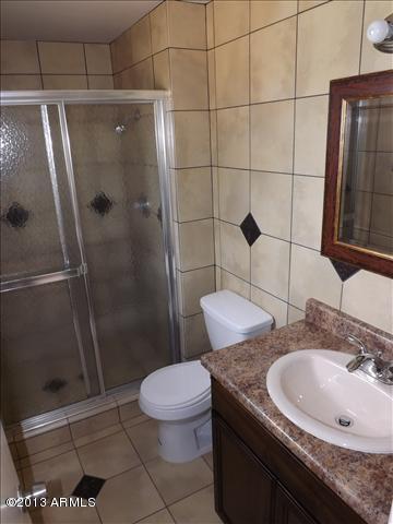 6520 West Berkeley Road Phoenix, AZ 85035 - Photo 13 of 22 a bathroom with a granite countertop sink toilet and shower